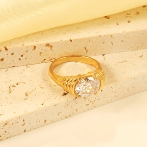 Vintage gold ring with large oval clear gemstone and textured band on stone display