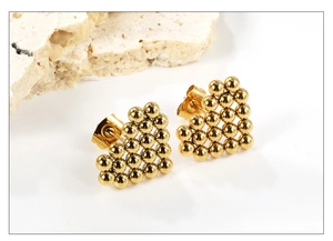 Detailed view of gold triangular stud earrings with polished stainless steel beads
