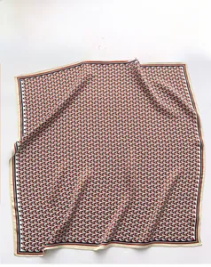 Detail showing geometric triangle pattern and refined edge stitching of the silk scarf