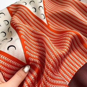 Detailed macro view of the crescent moon pattern and geometric design on the silk scarf