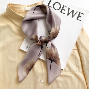 Elegant purple silk scarf with brown ginkgo leaf print worn on a yellow shirt collar