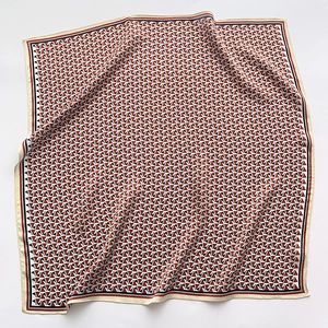 Detailed close-up of geometric pattern on 70x70 silk scarf with orange and black borders