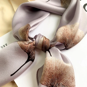 Macro shot of silk scarf with ginkgo leaf print and high-quality hemmed edges