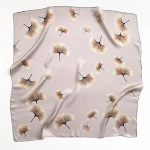 Detailed texture of lilac grey silk scarf featuring elegant ginkgo leaf patterns