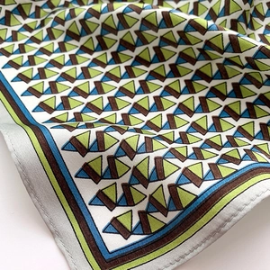 Detail of silk scarf with geometric triangle patterns and precise stitched edges