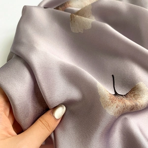 Detail of soft lavender silk scarf with ginkgo leaf print and elegant satin texture
