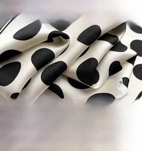 Macro view of luxurious mulberry silk fabric with elegant large black polka dots