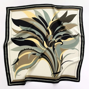Dettaglio di un foulard in seta con trama liscia e motivo a foglie di piante