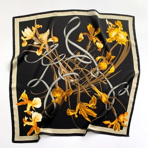 Dettaglio ravvicinato di un foulard in seta 70x70cm con motivi di iris gialli su nero