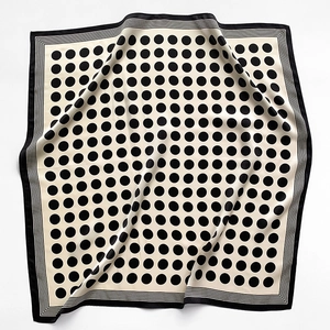 Detailed view of the elegant black polka dot silk scarf with classic border stripes
