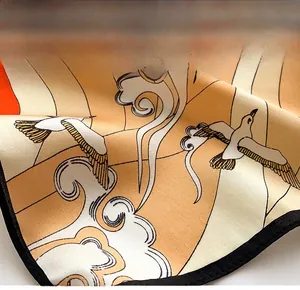 Detailed view of silk scarf with crane and cloud patterns and fine stitched edges