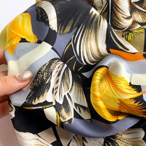 Dettaglio di un foulard di seta con tulipani gialli e una morbida trama satinata