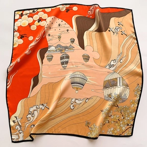 Detailed close-up showing silk scarf texture with hot air balloon and mountain prints