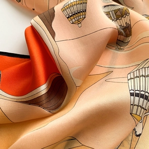 Close-up of printed silk square scarf featuring hot air balloons and mountain patterns