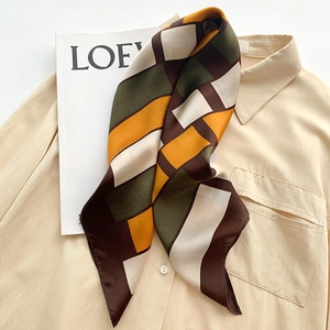 Plaid silk scarf in earth tones of brown and olive green on a striped shirt