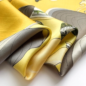 Detail of silk scarf showing yellow oriental clouds and smooth glossy fabric texture