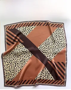 Flat lay of leopard print silk scarf featuring geometric patterns and satin texture