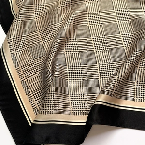 Detailed close-up of houndstooth silk scarf showing soft texture and geometric patterns