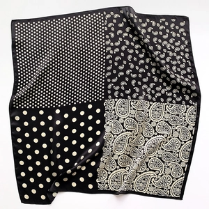 Detail of square silk scarf with paisley and polka dot patterns in black and white finish
