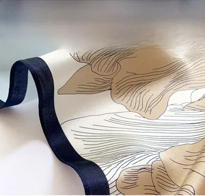 Gros plan de la couture de bordure fine sur foulard en soie avec motif floral beige