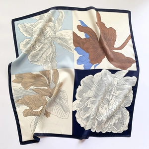 Gros plan détaillé d'un foulard en soie à fleurs montrant la texture satinée et les coutures