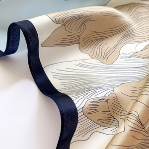 Gros plan d'un foulard en soie élégant avec motifs dorés et bords ourlés bleus