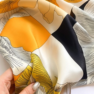 Détail du foulard en soie à imprimé floral montrant la texture douce et satinée