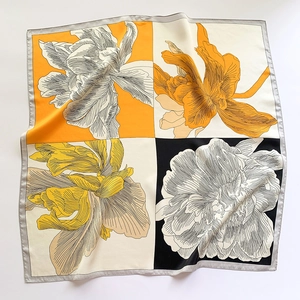Vue détaillée d'un grand foulard carré en soie avec imprimé floral et design bicolore