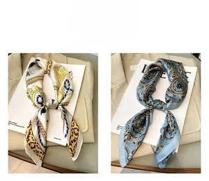 Détail de deux foulards en soie à motifs sur blazer beige et fond de livre d'art