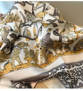 Gros plan du foulard en soie plié avec illustrations vintage et motifs de fleurs