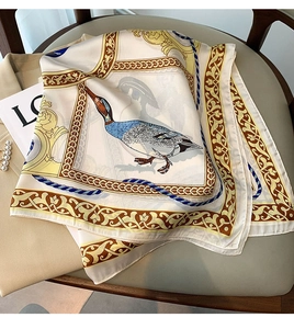 Détail d'un foulard carré satiné avec imprimé canard colvert et motifs baroques sur chaise