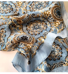 Détail d'un foulard en soie bleu clair avec imprimé mandala floral et texture lisse