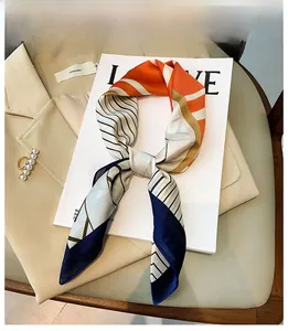Detail shot of a geometric silk scarf tied over a magazine and a chic khaki suit blazer