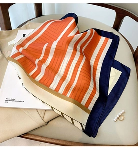 Detail showing high-quality silk texture square scarf with orange and blue stripes