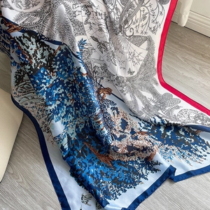 Détail d'un foulard en soie avec motifs de forêt et bords colorés contrastés