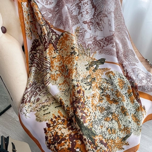 Détail d'un foulard en soie à imprimé vintage avec motifs d'arbres et bordure orange vif