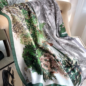 Détail d'un foulard en soie avec imprimé forêt verte et oiseaux sur un fauteuil