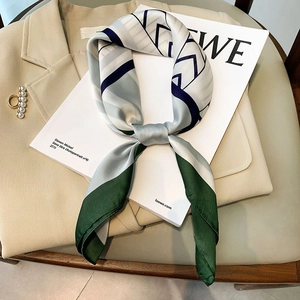 Elegant geometric stripe silk square scarf with deep green and blue tones on a blazer