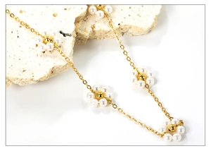 Vue macro d'un collier de fleurs en perles dorées délicates sur un fond de pierre