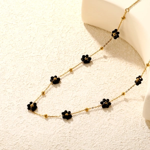 Élégant collier de fleurs en perles avec pétales en cristal noir et billes dorées