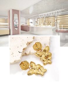 Makro-Detail von 18K vergoldeten Schmetterlings- und Sonnenblumen-Ohrringen auf Stein