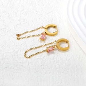 Fashion gold drop earrings with pink cubic zirconia and long chain tassels on white background