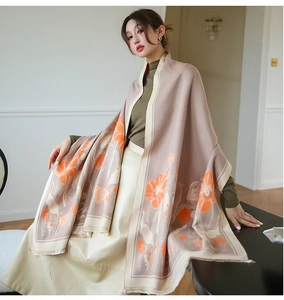 Détail d'une écharpe florale vintage avec fleurs orange et franges élégantes