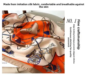 Detailed view of silk-like square scarf featuring classic orange chain patterns and fine edges