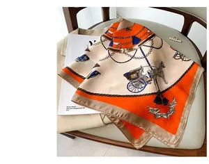 Detailed view of vintage orange and beige silk scarf with carriage and chain prints