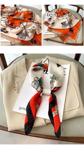 Detailed view of square silk scarves with luxury horse carriage and chain patterns