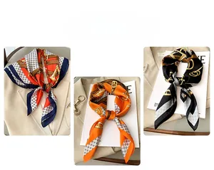 Détails de foulards en satin à motif chaîne utilisés comme bandeau et décor de sac