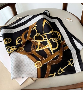 Détail macro d'un foulard carré en soie avec des motifs de chaînes dorées vintage