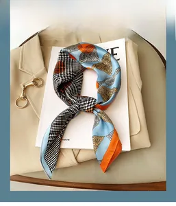 Detail of silk-feel scarf featuring contrast paisley and houndstooth patterns on chic blazer