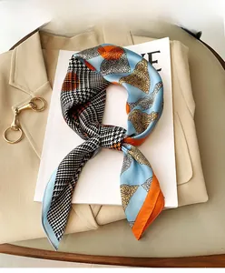 Detail of silk-feel scarf with paisley and houndstooth patterns on a light blazer